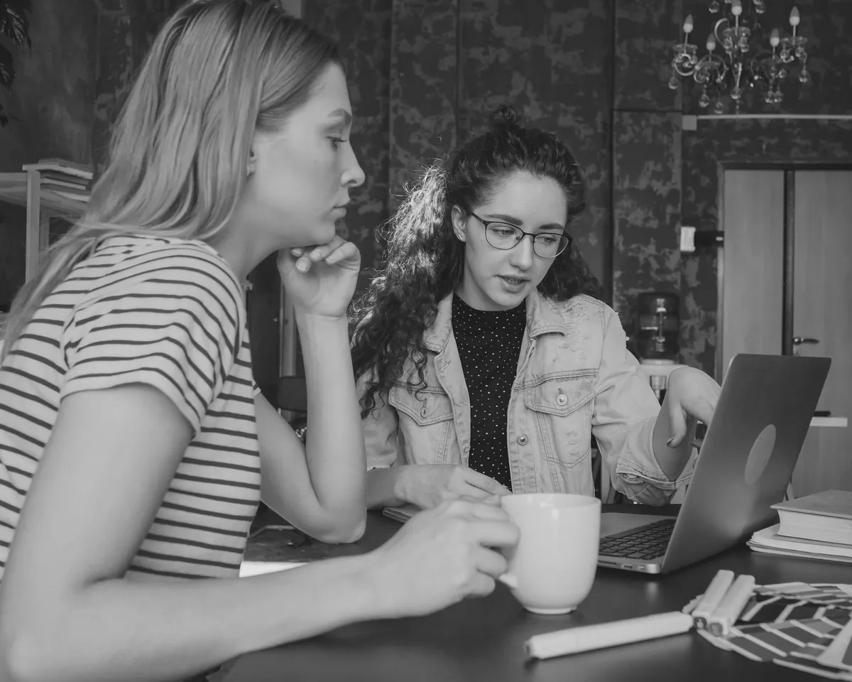 Woman checking her email with tea in her hand