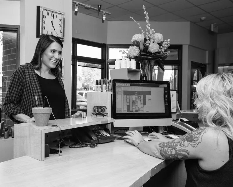 Two women at a counter talking to a customer